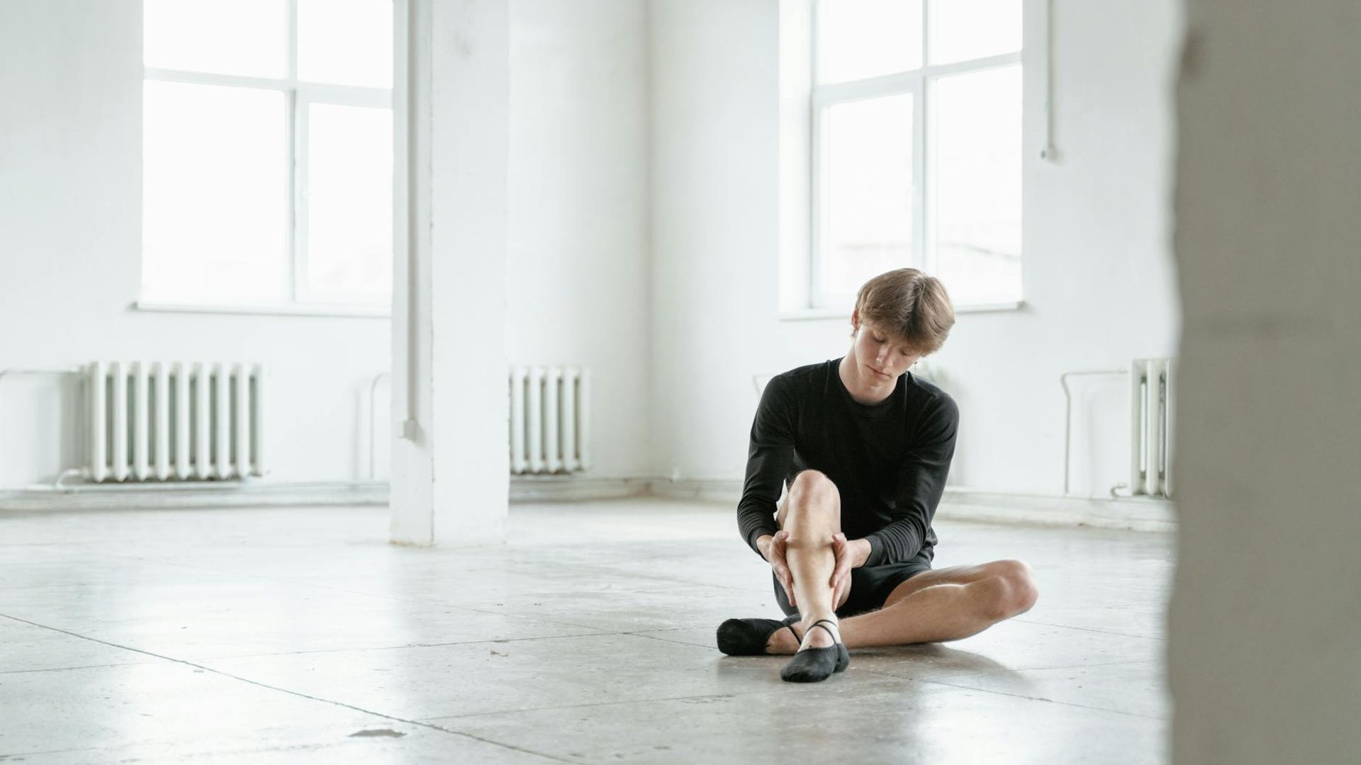Person performing dynamic exercises in a bright minimalist studio space